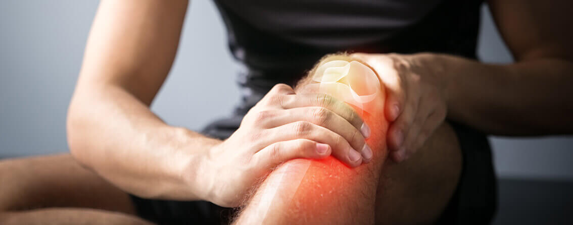 Man holding knee lit up in red due to knee pain.